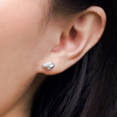 Fine jewellery, silver jewellery, hypoallergenic, tarnish-free, close-up front view of a silver ear studs embedded with crystals worn on a person's ear